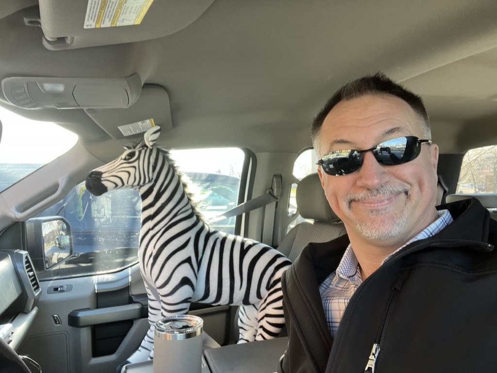 Frank riding shotgun in the passenger seat of John's F-150, facing forward like a co-pilot